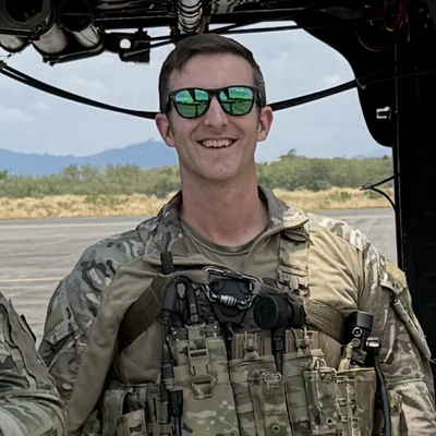 Christian Lakars standing in front of a Black Hawk helicopter