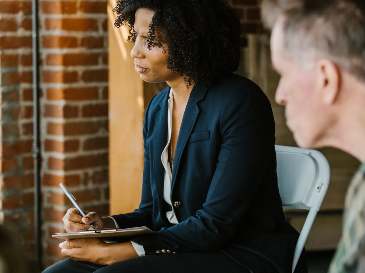 A career coach takes notes while speaking with a service member