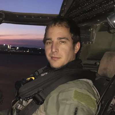 James Otto in the cockpit of a helicopter at dusk